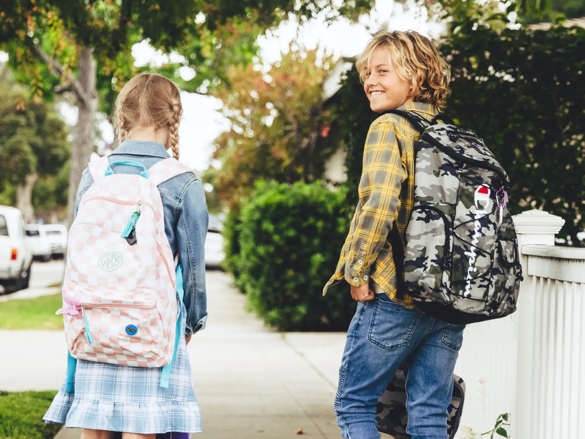 Two kids walking to school with backpacks