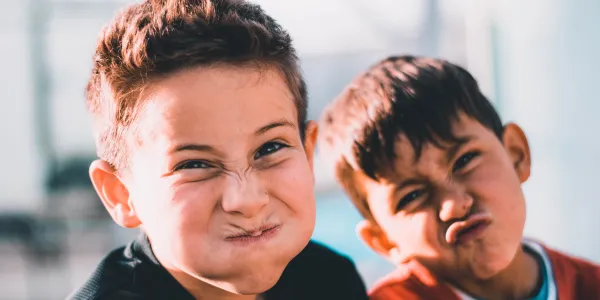 Two smiling boys posing together outdoors — Spriggy kids savings blog