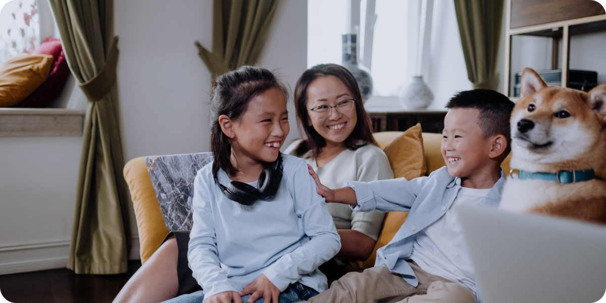 Three children and a dog sitting together on the couch