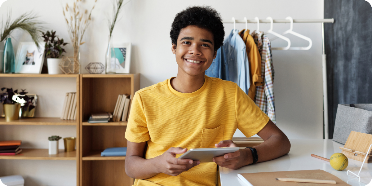 Teenager holding a tablet at a desk