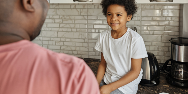 Dad and son chatting in the kitchen about money